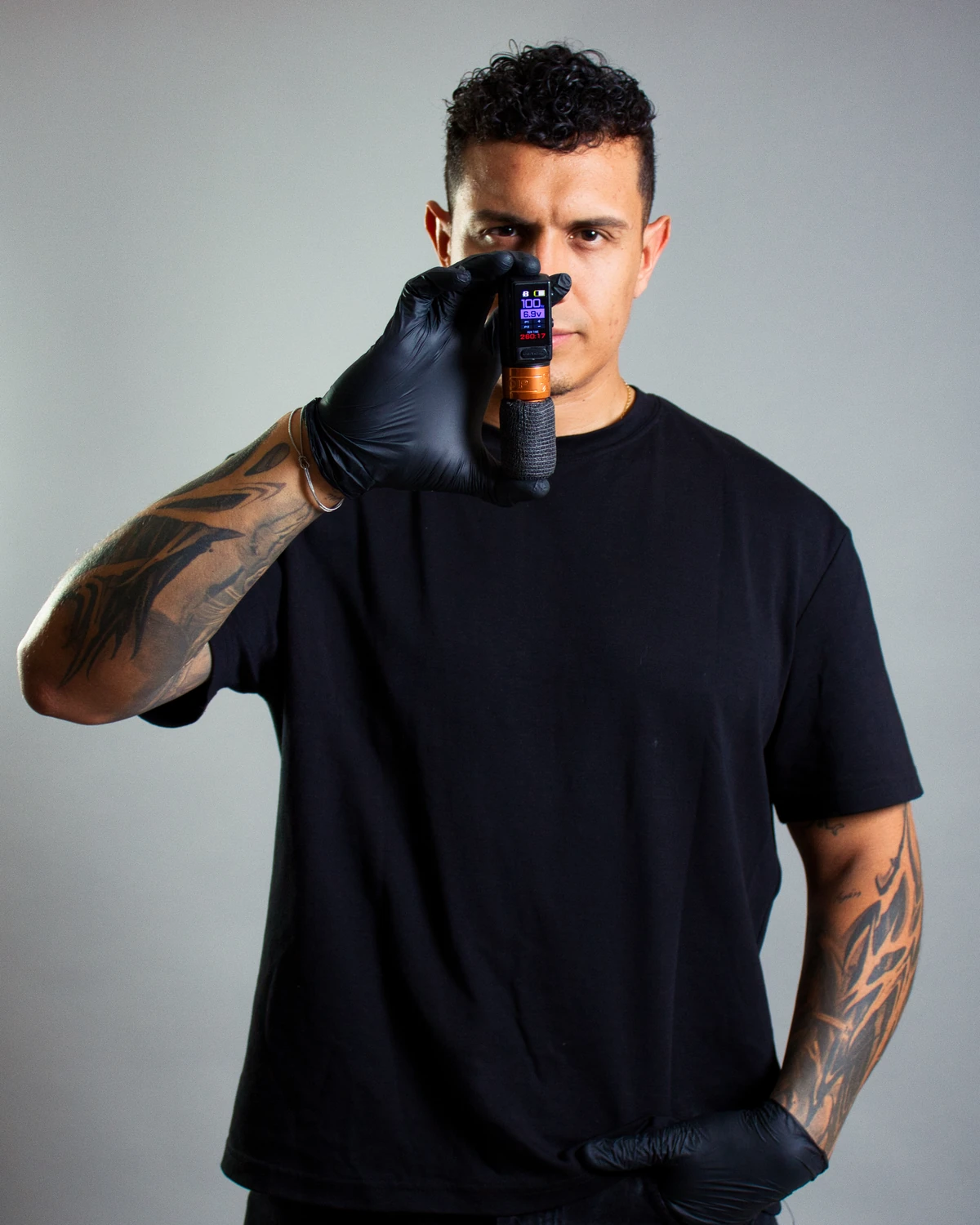 Jhonatan Pérez sosteniendo una máquina de tatuar en Rembranci Studio